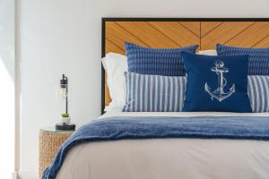 a bed with blue and white pillows and an anchor pillow at Varanda Azul - First Mate Loft (City Centre) in Ponta Delgada