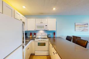 a kitchen with white cabinets and a white stove top oven at Coastal Tranquility in Neskowin