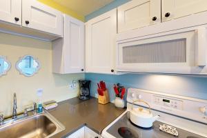a kitchen with white cabinets and a sink at Coastal Tranquility in Neskowin +21 photos