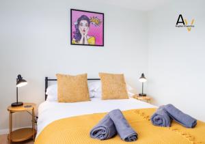 a bedroom with a bed with towels on it at Spacious Two-Bedroom House - Driveway Parking, Garden Space, Great for Relocation By AV Hughes Properties in Northampton