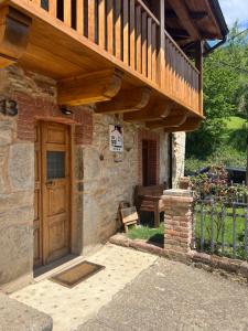 ein Haus mit einer Holztür und einem Balkon in der Unterkunft La Casita de Verdiago in Verdiago