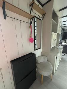 a living room with a tv and a chair at Tiny Beachhouse - New Vennepark Wenduine in Wenduine +12 photos