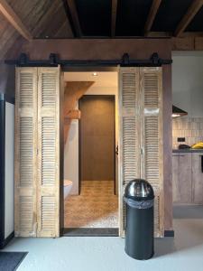 a door into a bathroom with a trash can at De Windpeluw - Daar bij die Kempermolen in Breedenbroek