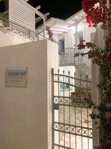 een wit gebouw met een hek met bloemen erop bij Okeanos in Skiathos-stad