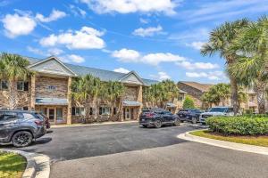 a parking lot with cars parked in front of a building at Pelicans Reef by the beach in Myrtle Beach
