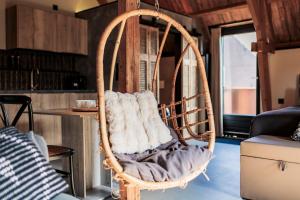 a wooden swing chair in a living room at Het Spoorwiel - Daar bij die Kempermolen - Achterhoek in Breedenbroek