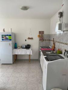 a kitchen with a sink and a white refrigerator at Casita María in Puerto San Julián