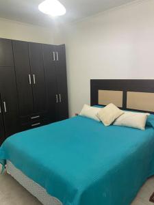 a bedroom with a blue bed and black cabinets at Casita María in Puerto San Julián