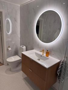 Leilighet في ترومسو: حمام مع حوض ومرحاض ومرآة