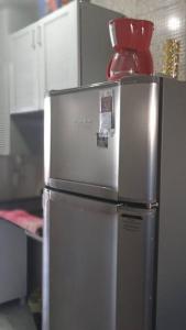a silver refrigerator with a container on top of it at Loft Temporada Praia do Meio in Natal