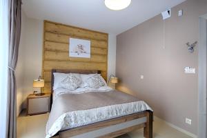 a bedroom with a bed with a wooden headboard at Gordonówka Residence & SPA- sauna i jacuzzi-przeżyj niezapomniany pobyt in Szaflary +70 photos