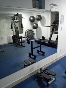 a room with a gym with weights and a mirror at Loft Temporada Praia do Meio in Natal