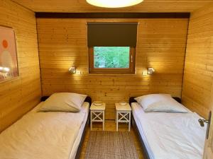 two beds in a log cabin with a window at Chalet 22 Bernau in Bernau im Schwarzwald