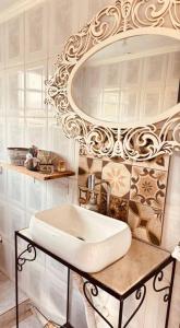 Un baño blanco con lavabo y espejo. en Lake House, en Morungaba