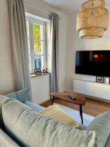 a living room with a couch and a tv at Allerhaus Apartments am Ackerbürgerhaus in Verden