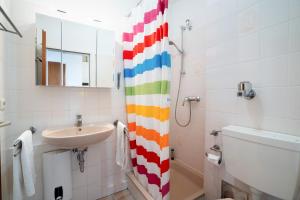 een badkamer met een wastafel, een toilet en een spiegel bij DKK7 Ferienwohnung Abendsonne F in Niendorf +17 foto's