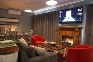 a living room with a fireplace and a tv at Game View Lodge in Vryburg