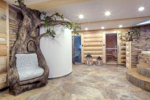 a living room with a tree mural and a chair at Gordonówka Residence & SPA- sauna i jacuzzi-przeżyj niezapomniany pobyt in Szaflary