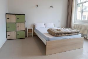 a bedroom with a bed and a dresser at La Brasserie Hostel in Metz
