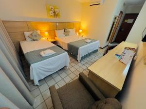 a hotel room with two beds and a couch at Hotel Dan Inn Uberaba & Convenções By Nacional Inn in Uberaba