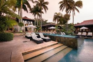 a resort with a pool with lounge chairs and palm trees at Zimbali Suites 212, Zimbali Estate in Ballito