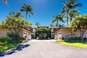 Una casa con palmeras y una entrada para coches. en Mauna Lani Villa A-22, en Waikoloa