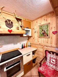 eine Küche mit Holzwänden und einem roten Stuhl in einem Zimmer in der Unterkunft Le Grenier de Olga e Mario in Pré-Saint-Didier