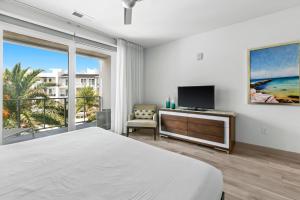 Un dormitorio con una cama y un televisor y una ventana. en The Pointe 333, en Inlet Beach