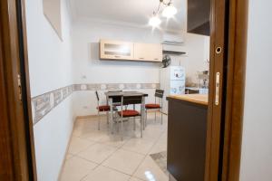 una pequeña cocina con mesa y sillas en A 31 Passi dal Mare, en Bari