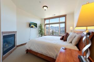 a bedroom with a large bed and a fireplace at Peregrine Point 204 in Durango Mountain Resort +20 photos