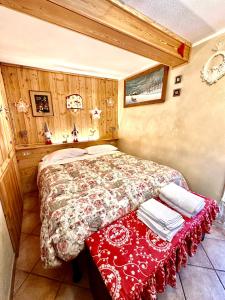 ein Schlafzimmer mit einem Bett mit einer roten Decke in der Unterkunft Le Grenier de Olga e Mario in Pré-Saint-Didier