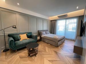 ein Schlafzimmer mit einem Sofa, einem Bett und einem Tisch in der Unterkunft 台南圈旅 in Tainan