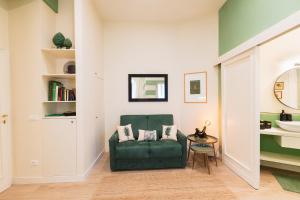 Una sala de estar con un sofá verde y una mesa. en Cozy olive green flat, en Florencia