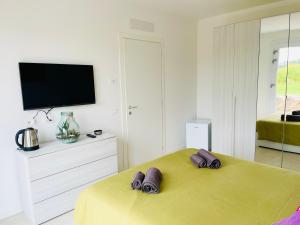 a bedroom with a yellow bed with two slippers on it at Fermata 35 in Sandra