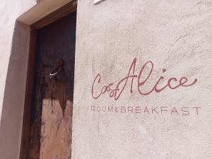 a sign on the side of a building with a door at CasAlice Room & Breakfast in Santarcangelo di Romagna