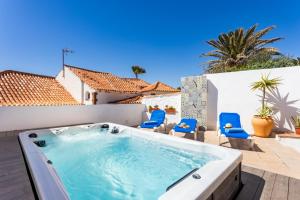 wanna z hydromasażem na patio z niebieskimi krzesłami w obiekcie Casa Naranja - Heated Pool - BBQ - Terrace - Free Wifi - Child & Pet-Friendly - 3 bedrooms - 6 people w mieście Poris de Abona
