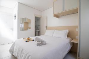 - une chambre avec un lit blanc et un plateau dans l'établissement PLT41 - Sacada Ampla com Churrasqueira, 3 Suítes, à Balneário Camboriú