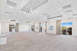 デスティンにあるSunDestin Resort Unit 0217の白い壁とシャンデリアが特徴の広い客室です。 +37枚の写真