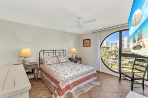a bedroom with a bed and a large window at Top Floor 2 Bed Condo I Close Walk to Beach in Marco Island