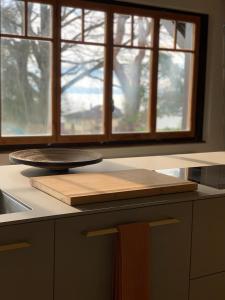 a kitchen counter with a cutting board and two windows at 'Le Petit Clos Suites'- Charming Getaway on Leman Lake in Nyon +37 photos