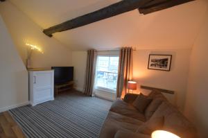 a living room with a couch and a tv at Wg Apartment in Macclesfield