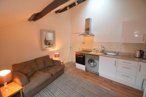 a living room with a couch and a kitchen at Wg Apartment in Macclesfield