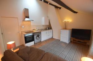 a living room with a couch and a kitchen at Wg Apartment in Macclesfield