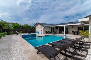 una piscina con sillas y una casa en New Listing Stunning 4 Bed I Heated Pool/Hot Tub, en Rookery Island