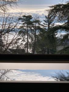 a view of a window with trees in the background at 'Le Petit Clos Suites'- Charming Getaway on Leman Lake in Nyon