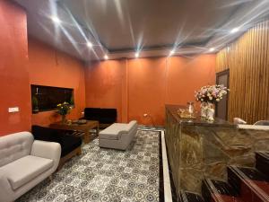 a living room with orange walls and white furniture at Vườn Mây Homestay Sapa in Sa Pa