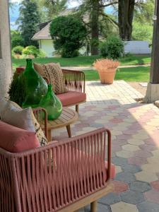 two wooden benches with green vases on a patio at 'Le Petit Clos Suites'- Charming Getaway on Leman Lake in Nyon