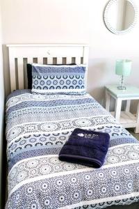 a bed with a blue and white comforter on it at 27 On Ray in Britannia Bay