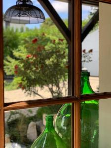 three green glass bottles sitting in a window at 'Le Petit Clos Suites'- Charming Getaway on Leman Lake in Nyon