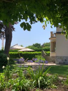 a garden with purple flowers and a building at 'Le Petit Clos Suites'- Charming Getaway on Leman Lake in Nyon